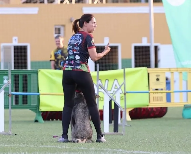 Woman training a dog at an agility course